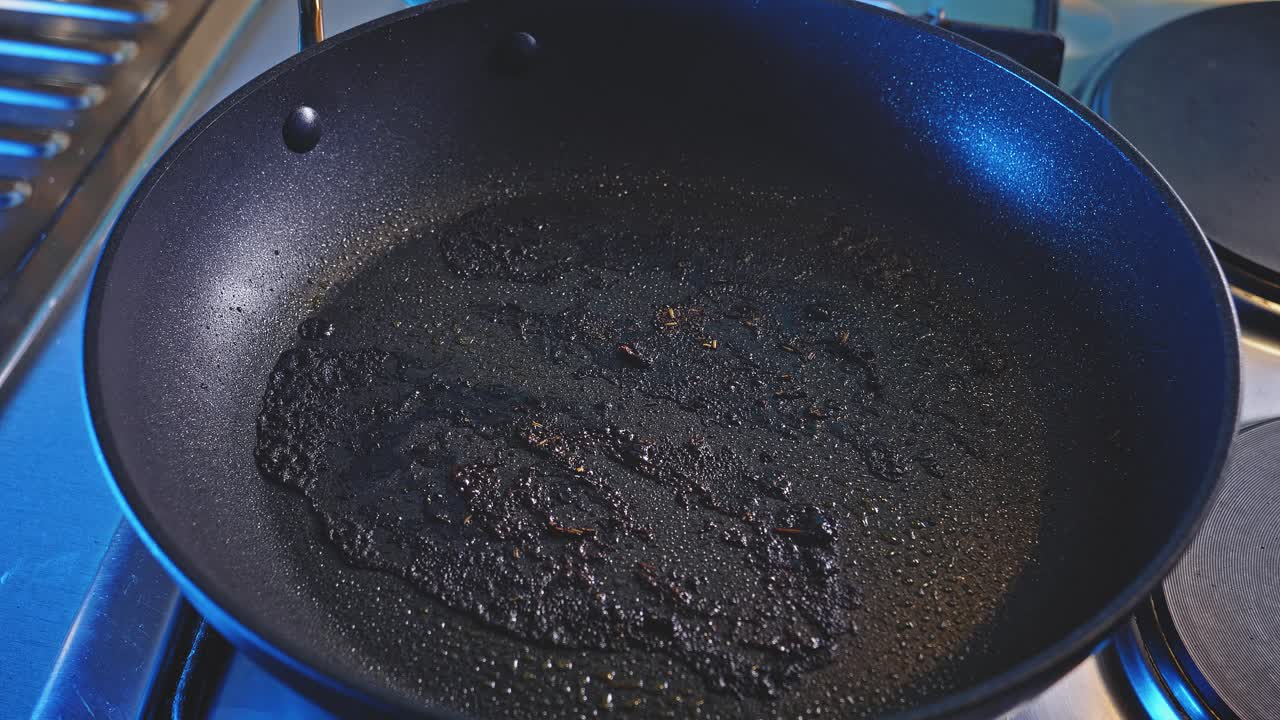 Padella usata e spruzzata con olio per cucinare melanzane a fette.