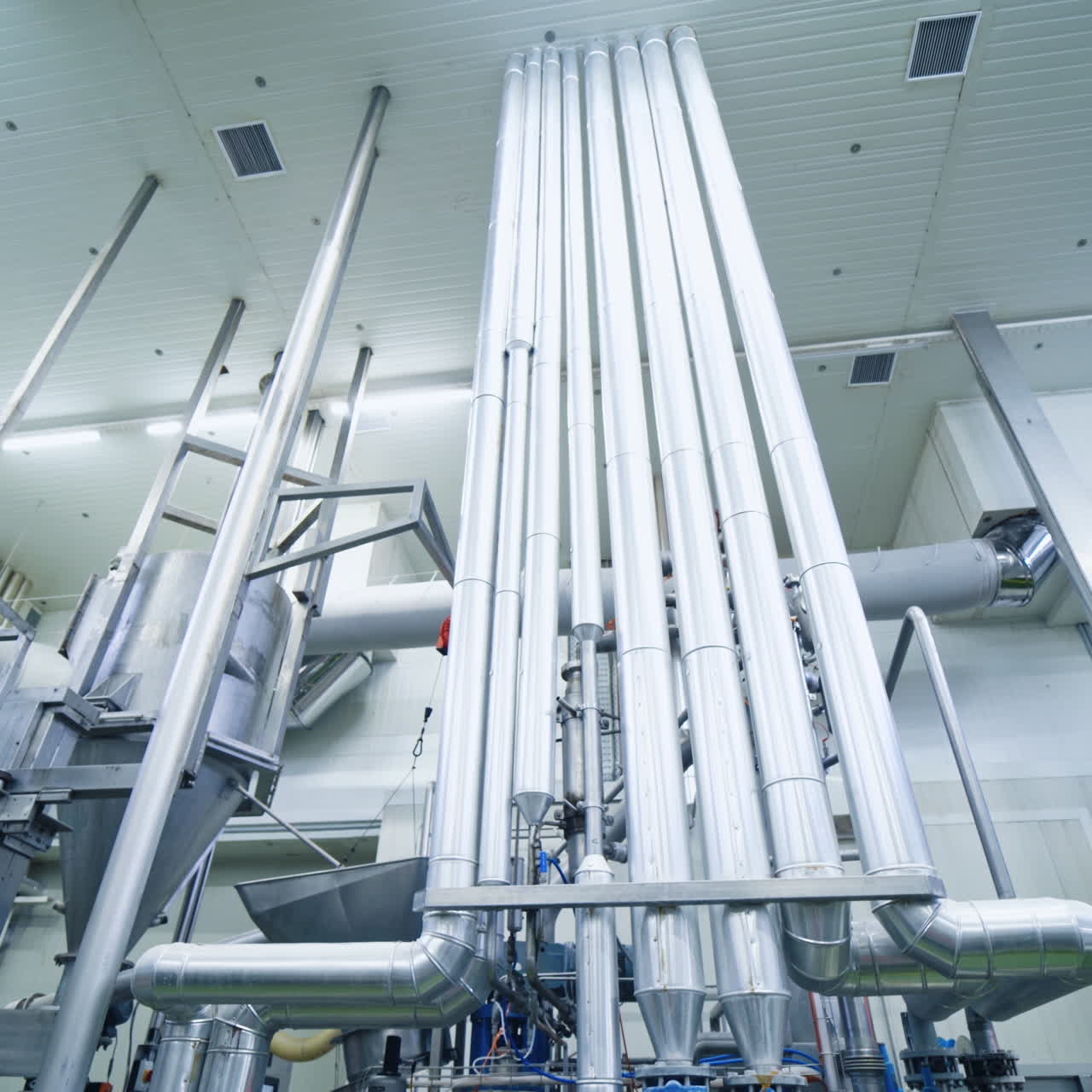 Modern equipment inside the industrial factory. Ventilation pipe system indoors. Manufacture concept. Motion camera down.