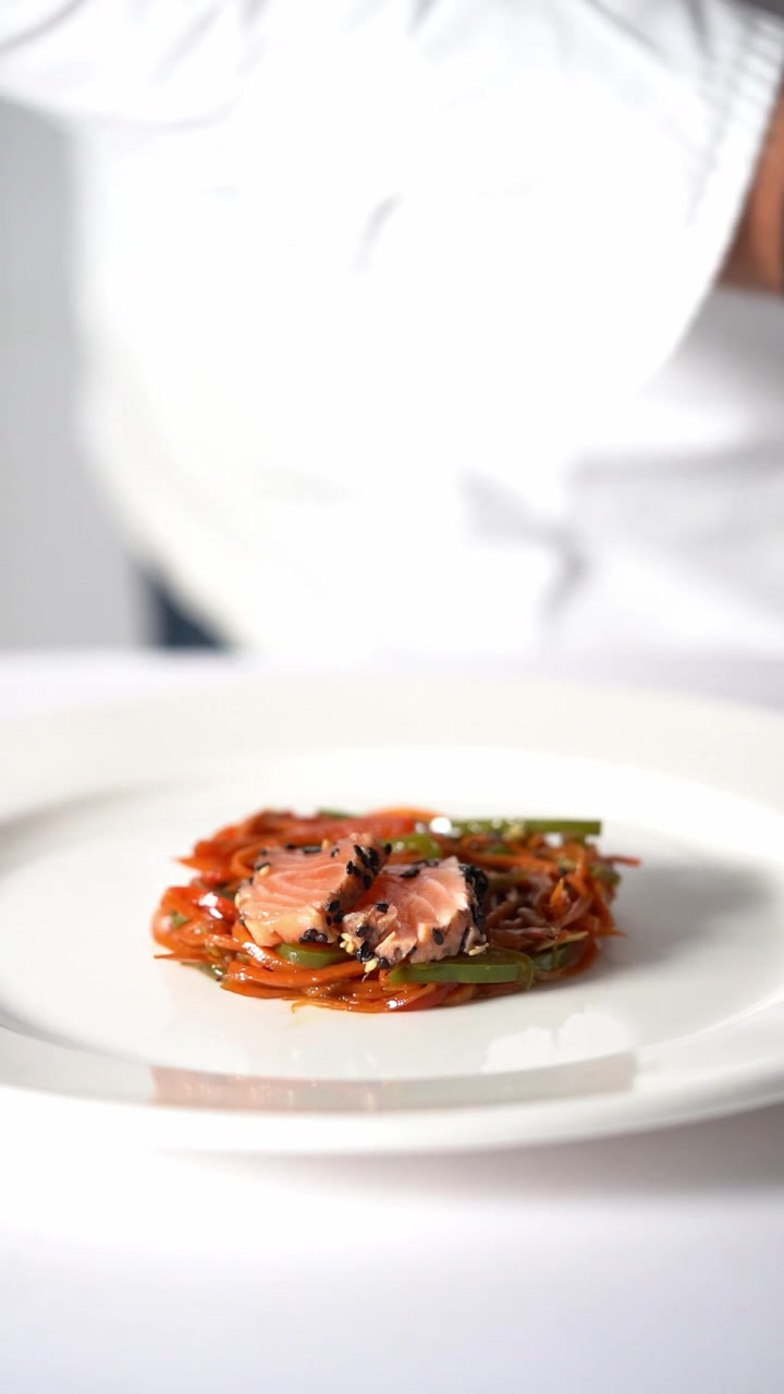 Kok anretter en gourmetret med grøntsager og kød i minimalistisk stil, nærbillede, indskudsbillede.