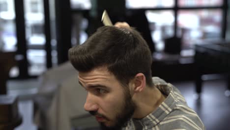 The-young-bearded-man-is-combing-his-hair