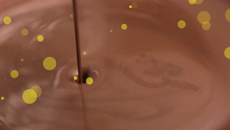 animation of gold dots over chocolate pouring