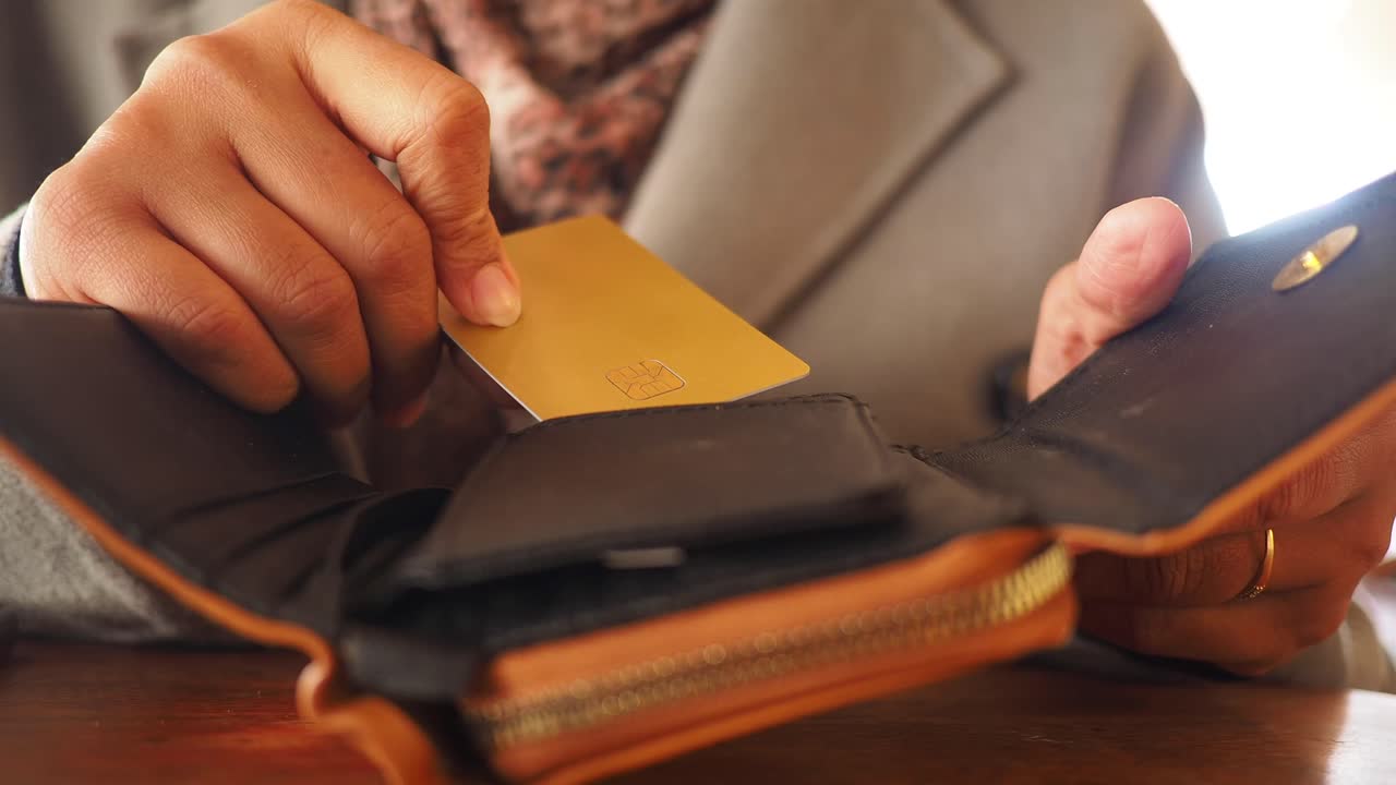 Person opening a wallet to retrieve a credit card