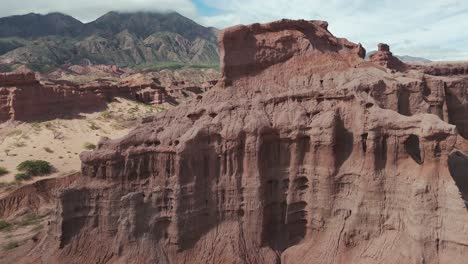 Majestic-red-rock-formations-in-Quebrada-de-las-Conchas,-Cafayate-with-mountains-in-the-background