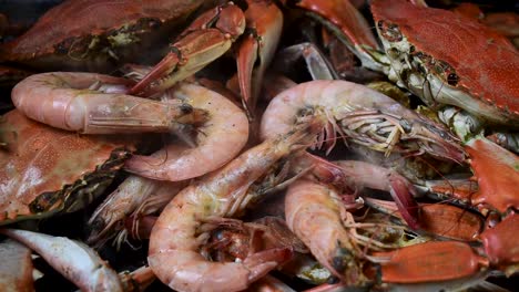 grupo de cangrejos azules humeantes y camarones grandes en pila