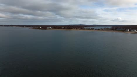 an aerial view of the calm waters of the long island sound off southold town beach on long island, ny on a cloudy day
