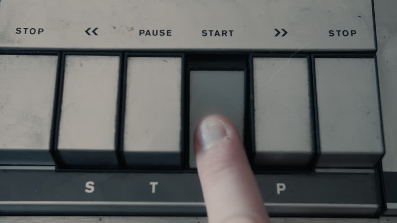 Finger Pressing Start Button on Vintage Audio Player