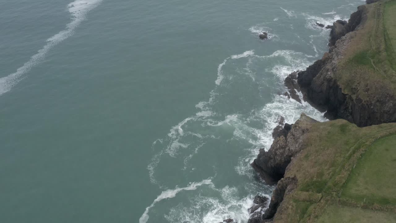 sobrevuelo aéreo rápido de campos verdes irlandeses, acantilados rocosos y océano