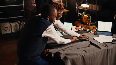african american tailors cutting garment