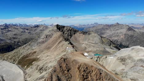 Aerial-flyover-around-Fuorcla-Trovat-peak-at-Diavolezza-in-Engadin,-Switzerland-with-360-views-of-Pers-glacier-and-other-peaks-of-the-Swiss-Alps-around-St