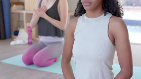 Se-Centró-En-Diversas-Mujeres-Fitness-Haciendo-Ejercicio-Y-Meditando-En-Una-Alfombra-En-Una-Habitación-Blanca,-En-Cámara-Lenta