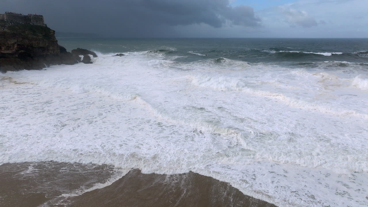 Nazare, Portugal North Beach on a day with giant waves. Famous iconic big wave professional surfing destination. Aerial drone shot