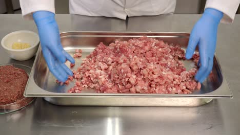 the butcher mixes different types of ground meat