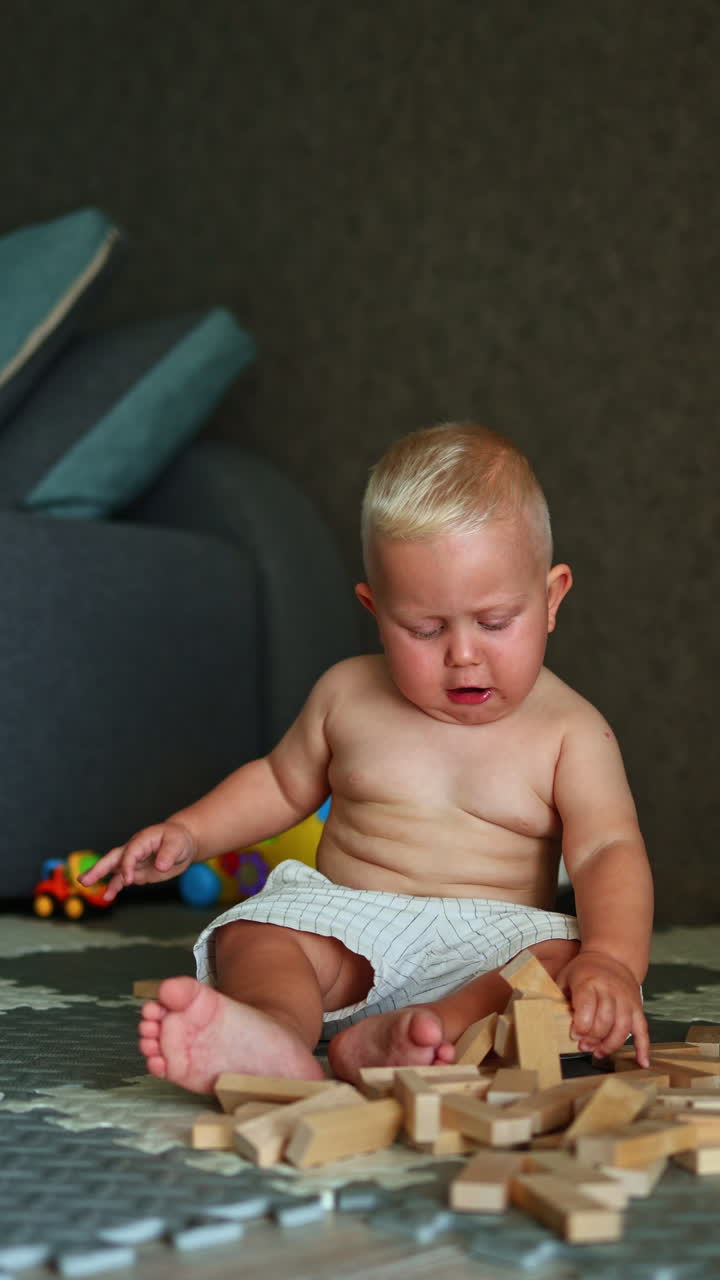 A little boy is playing on the floor at home. The child plays alone at home. Child development