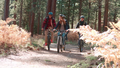 group of friends cycling past in a forest