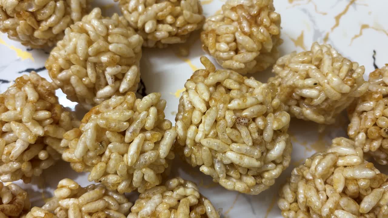 Laddus tradizionali indiani di riso soffiato ricoperti di jaggery, serviti su un piatto