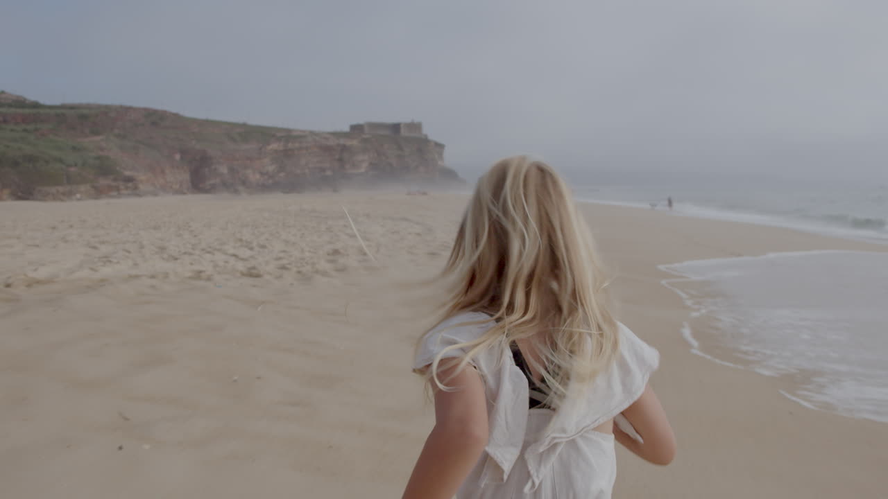 해변에서 실행하는 소녀