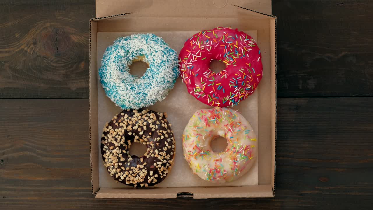 las manos de la mujer toman fotos con el teléfono inteligente de deliciosas rosquillas en la caja