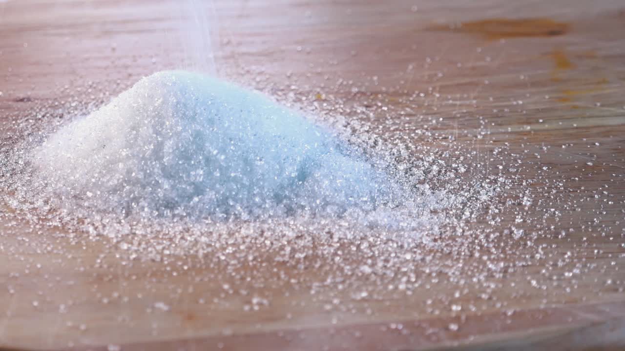 Slow Motion Shot of White Sugar Being Poured Onto a Wooden Board