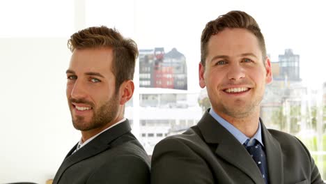 Smiling-businessmen-looking-at-camera