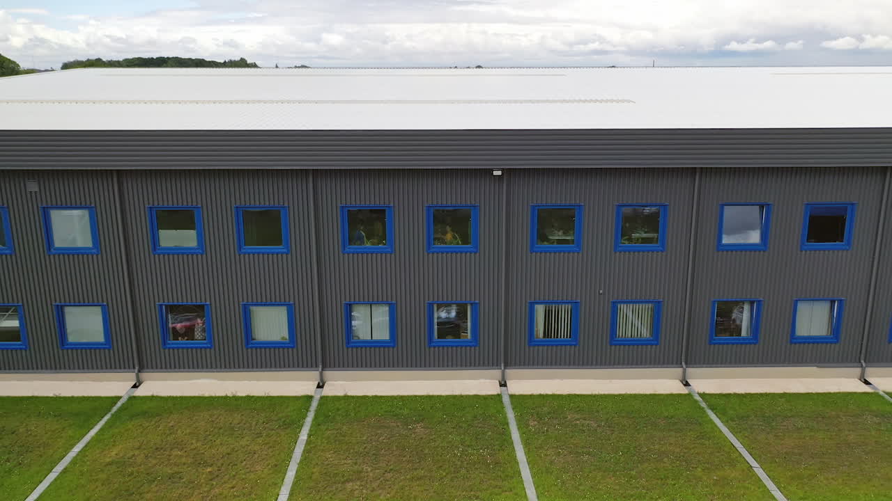 Modern two-storey building. Exterior of a new industrial building. View from outside on a business center in summer time.