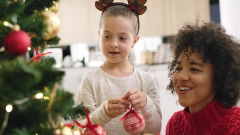 Handheld-Ansicht-Von-Mädchen-Und-Mama,-Die-Den-Weihnachtsbaum-Schmücken