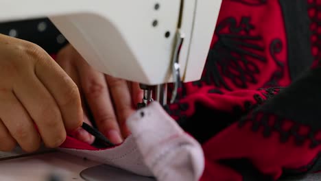 woman tailor sewing on electric machine a jacket