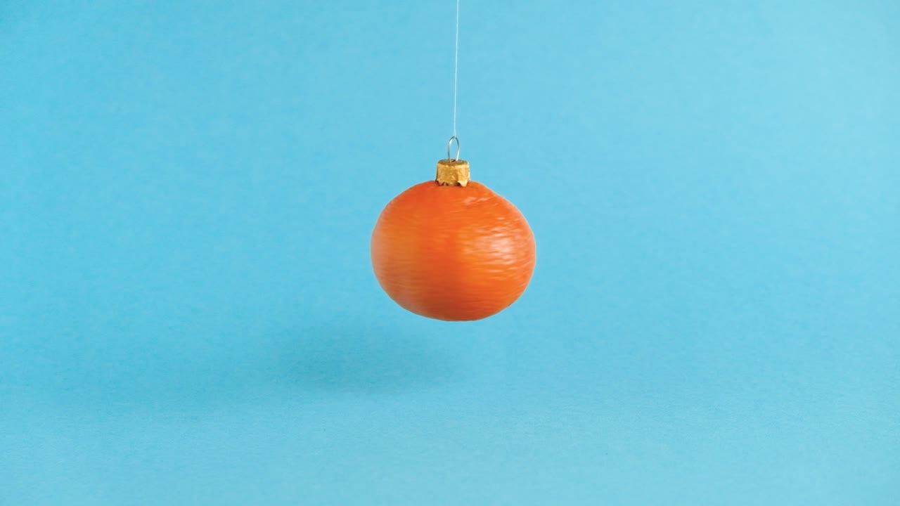 juguete de navidad volador y giratorio hecho de fruta de mandarina naranja. concepto minimalista de año nuevo. levitación