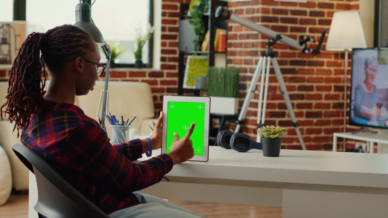 Young student analyzing digital gadget with greenscreen template