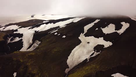 vista aérea del paisaje de montañas con nieve derretida, en un día de niebla, área de fimmvörðuháls, islandia