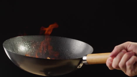 mushrooms stir-frying in a wok with flames