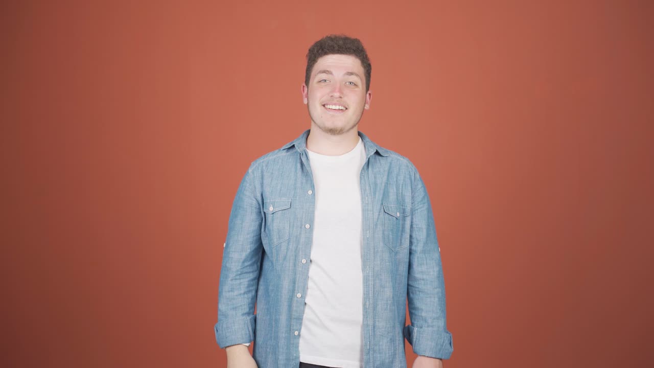 카메라를 향해 손을 흔드는 행복한 남자.