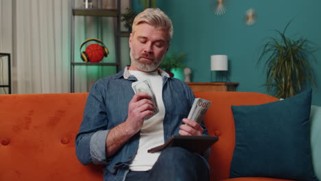 rich mature man counting money cash and use calculator, calculate domestic income earnings at home