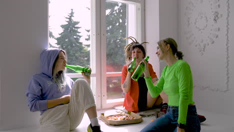 zoom out of a pizza party with three friends drinking beer