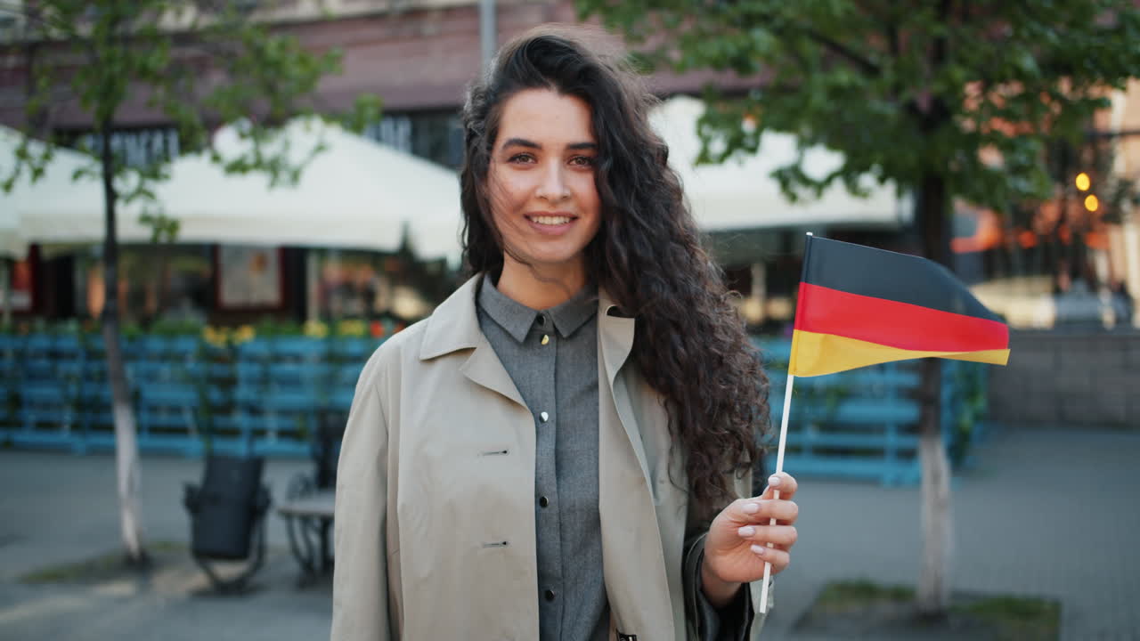 Woman holding German flag in city street