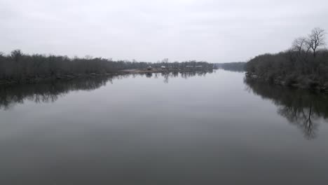 Flying-low-over-river-in-the-winter,-aerial-drone