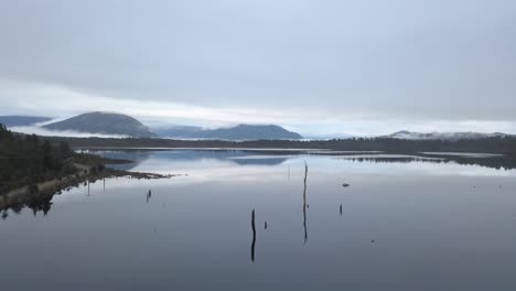 Embalse-De-Kumara-En-La-Costa-Oeste-De-La-Isla-Sur-De-Nueva-Zelanda-Antena-Cinematográfica-épica-En-Una-Mañana-Tranquila-Y-Espeluznante-Sobre-El-Lago