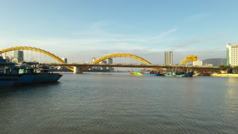 An-aerial-shot-over-the-dragon-bridge-with-traffic-and-skyline,-DaNang,Vietnam