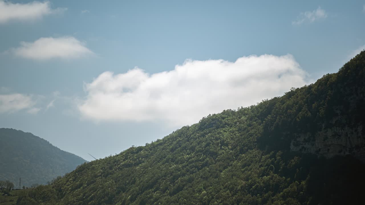 Time lapse of white clouds moving over the Apennine mountains forest, Italy