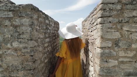 woman model in yellow dress walking on top of mayan ruin temple belize