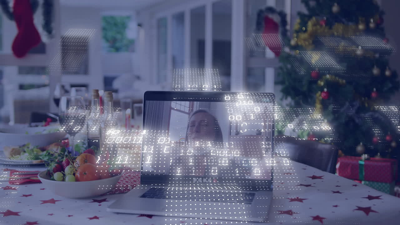 Laptop on festive table with digital data animation overlaying screen