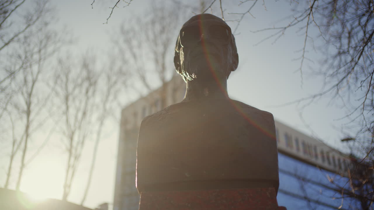 Inquadratura dal basso di una statua illuminata da una calda luce solare con effetto lens flare