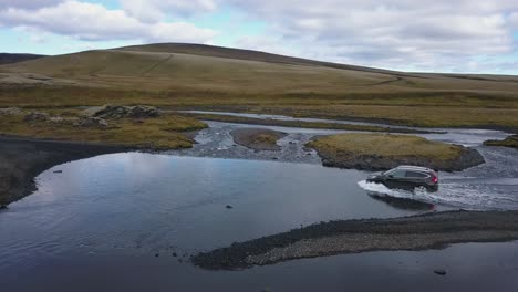 drone footage of a car river crossing in iceland