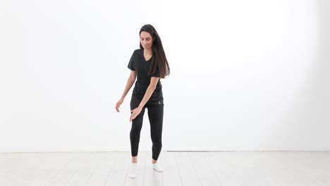 young woman dancing and exercising in a white studio
