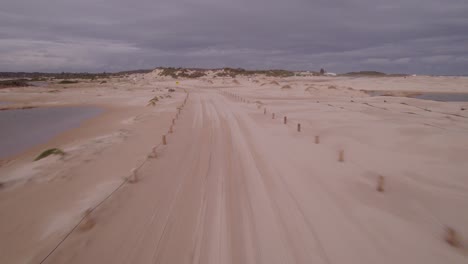volando rápido sobre un camino arenoso con gente caminando