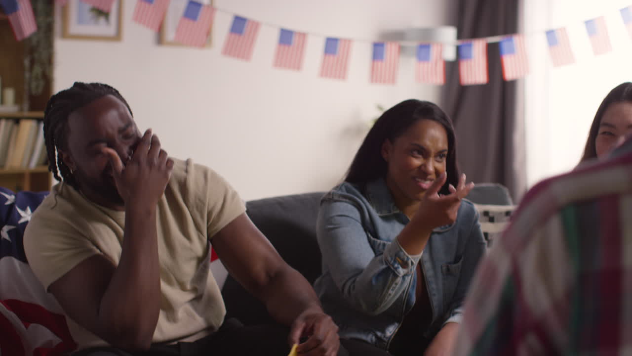 amigos en casa celebrando con fiesta por el día de la independencia de estados unidos 4 de julio hablando y comiendo bocadillos 2