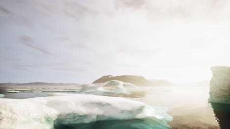 un grupo de icebergs flotando en la parte superior de un cuerpo de agua