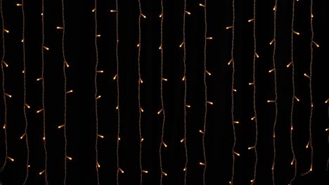 Golden garland lights on black background. New year or Christmas, versatile festive and magical backdrop