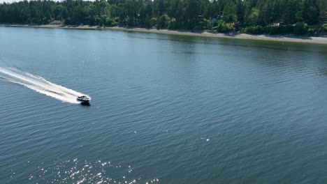 Aerial-view-of-a-motorboat-speeding-past-Herron-Island-in-Washington-State