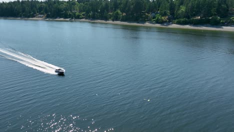 aerial view of a motorboat speeding past herron island in washington state