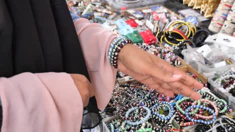 woman shopping for bracelets at a market